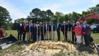 Group of people around dirt and shovels. 