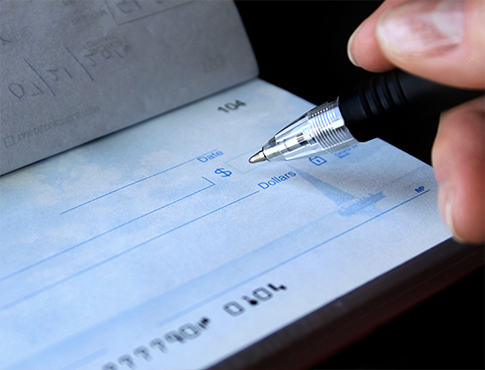 Closeup of pen writing on a check.