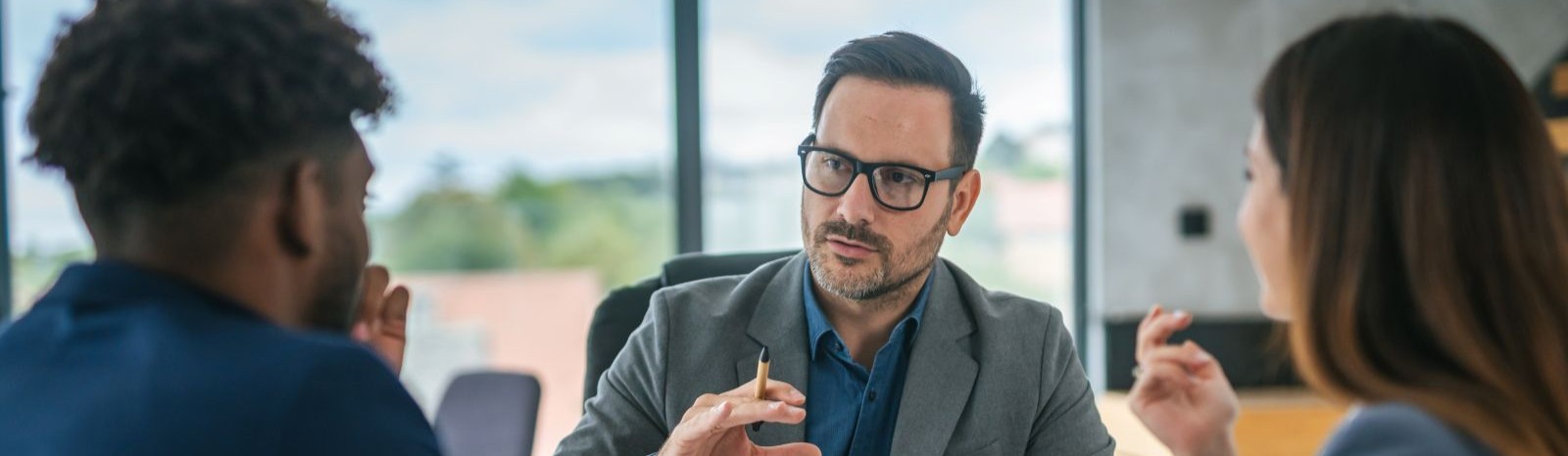 man looking at 2 other people and explaining something